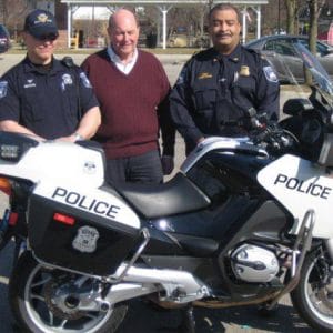 Police Motorcycle with Police officers standing behind it