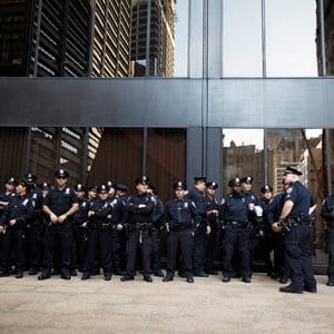 Group of police officers standing in front of glass windows. | Law Enforcement Department Staffing