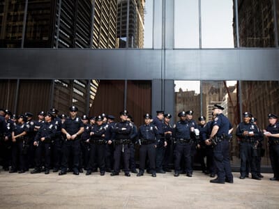 Group of police officers standing in front of glass windows. | Law Enforcement Department Staffing