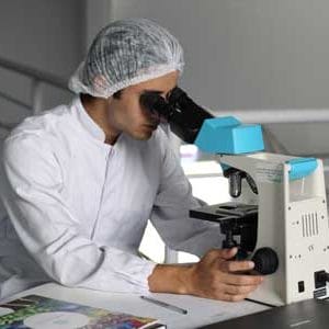 Medical Staff looking into a microscope | Free COVID-19 Testing
