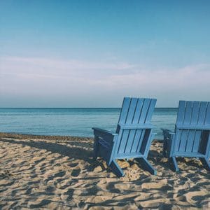 Two empty chair on the beach, facing the ocean. | Retirement With Adult Children | Lifestyle Choices | Medicare and Retirement