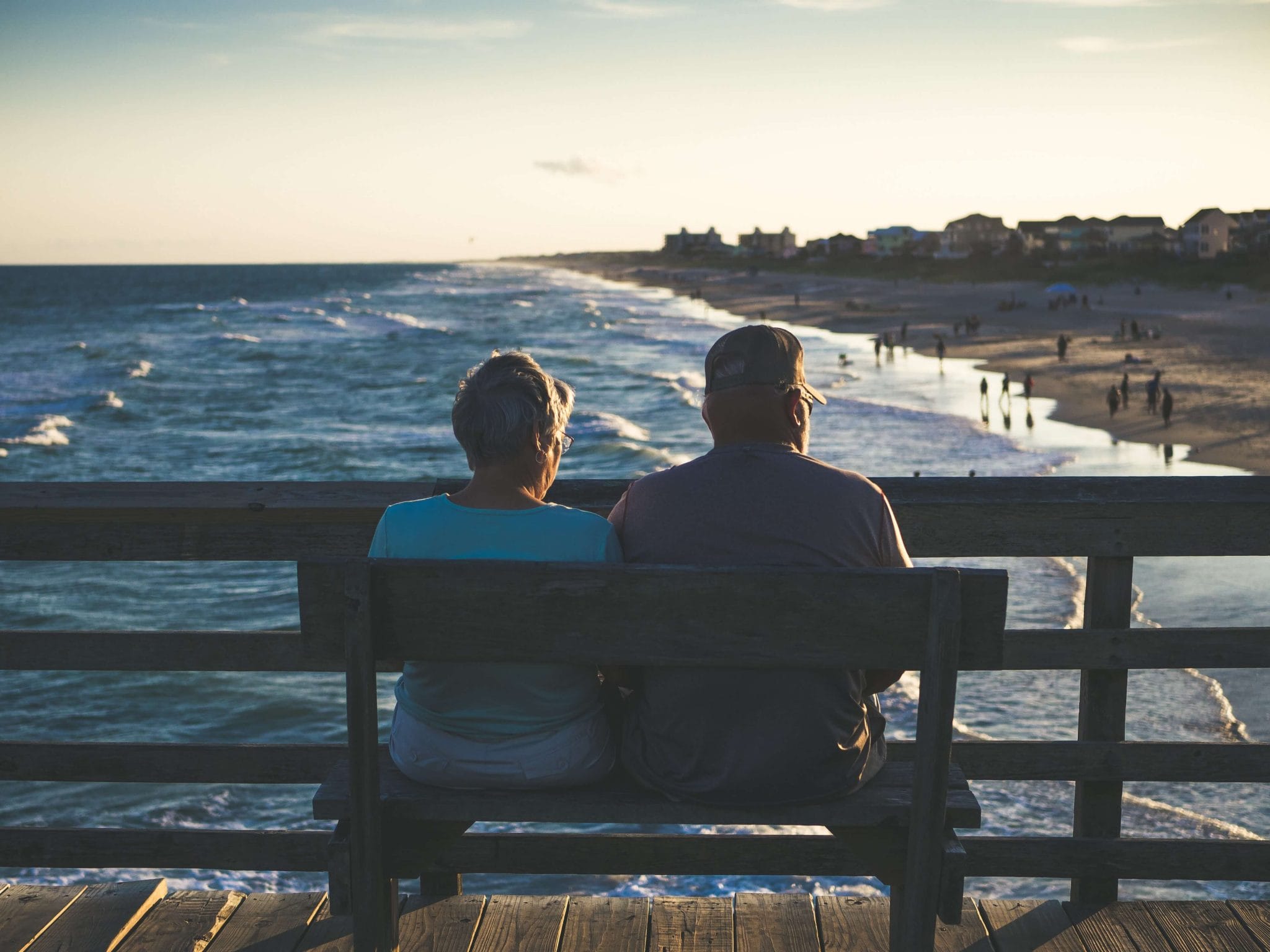 Couple sitting on the bench near an ocean | Retirement planning