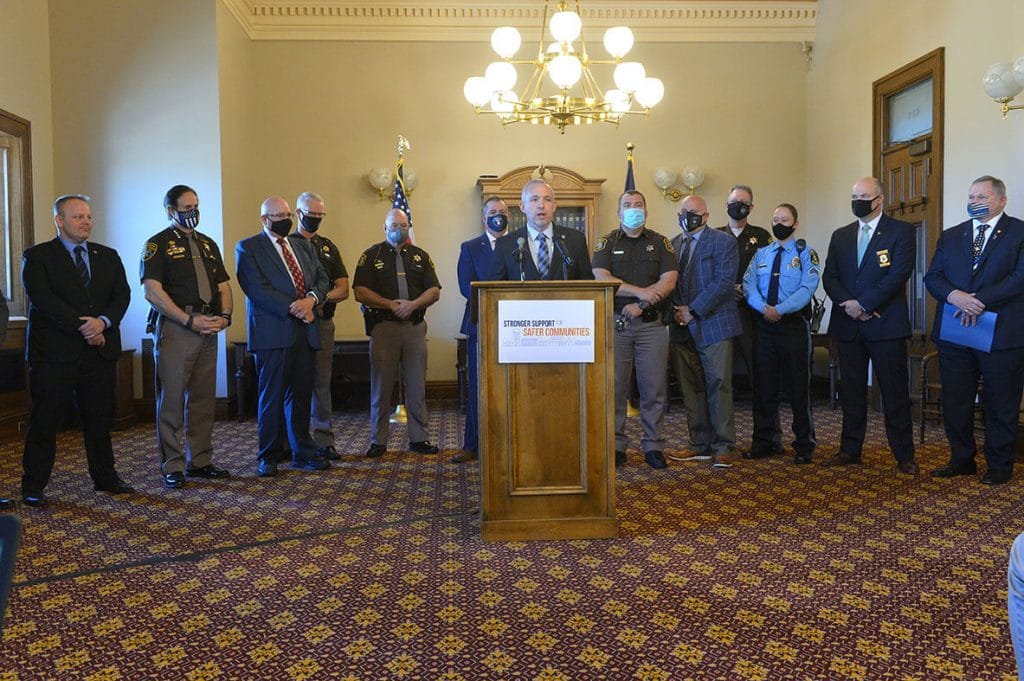 Michigan Speaker of The House Jason Wentworth speaking at a press conference with various law enforcement department heads standing behind him. | Training Plan to Support Local Police