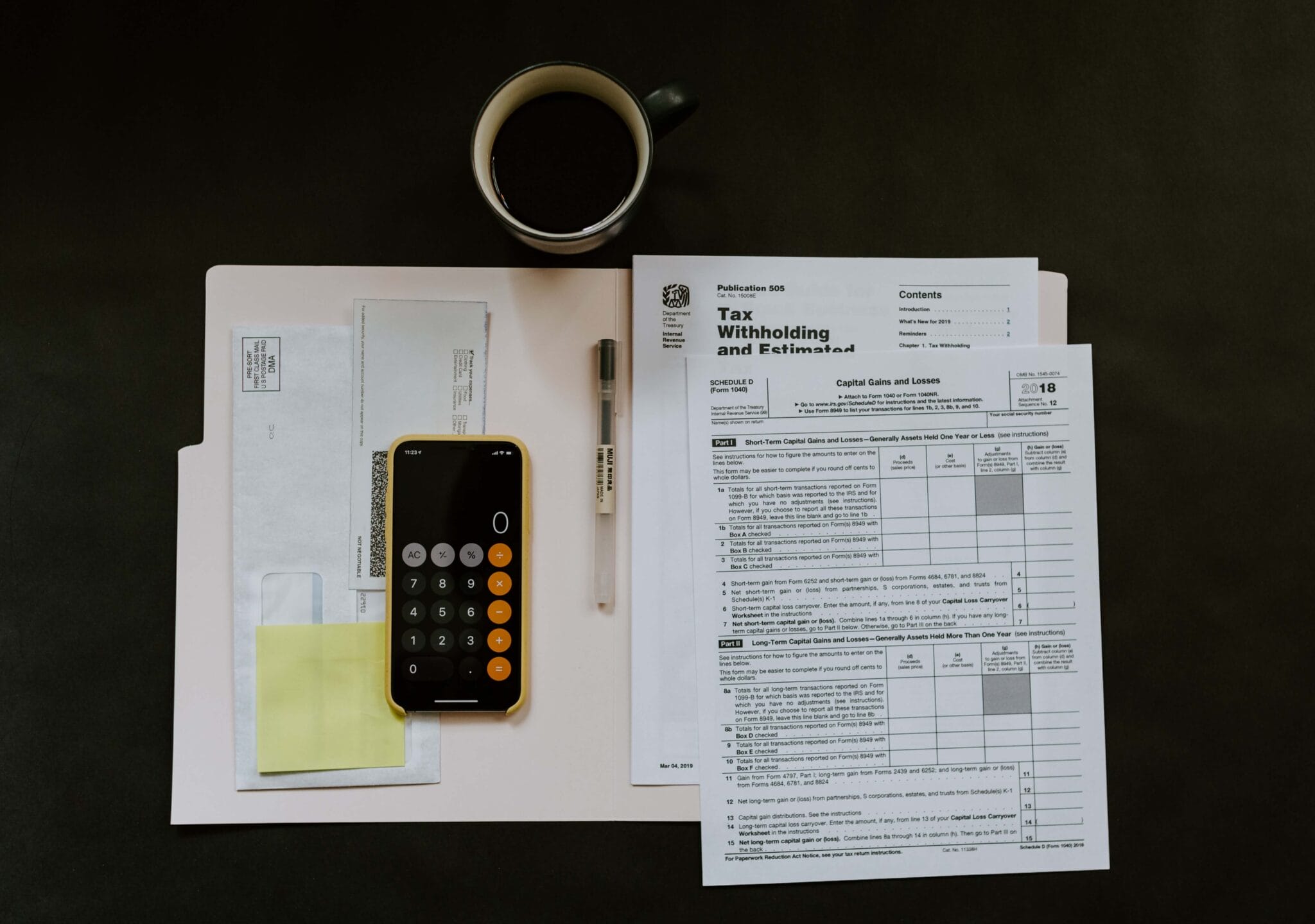 A phone laying on a folder of tax papers | 2022 Tax Reference Guide
