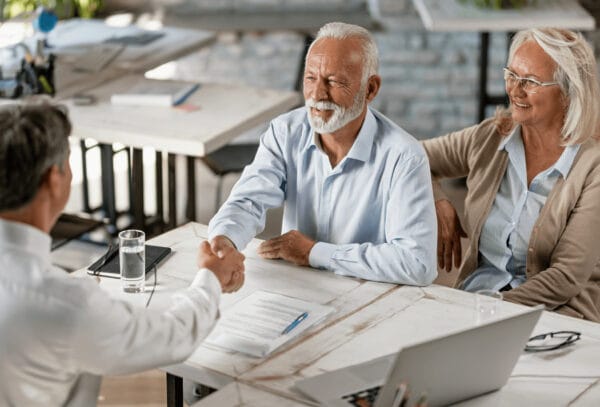 Retirement Portfolio | Elderly couple reviewing retirement portfolio with financial advisor