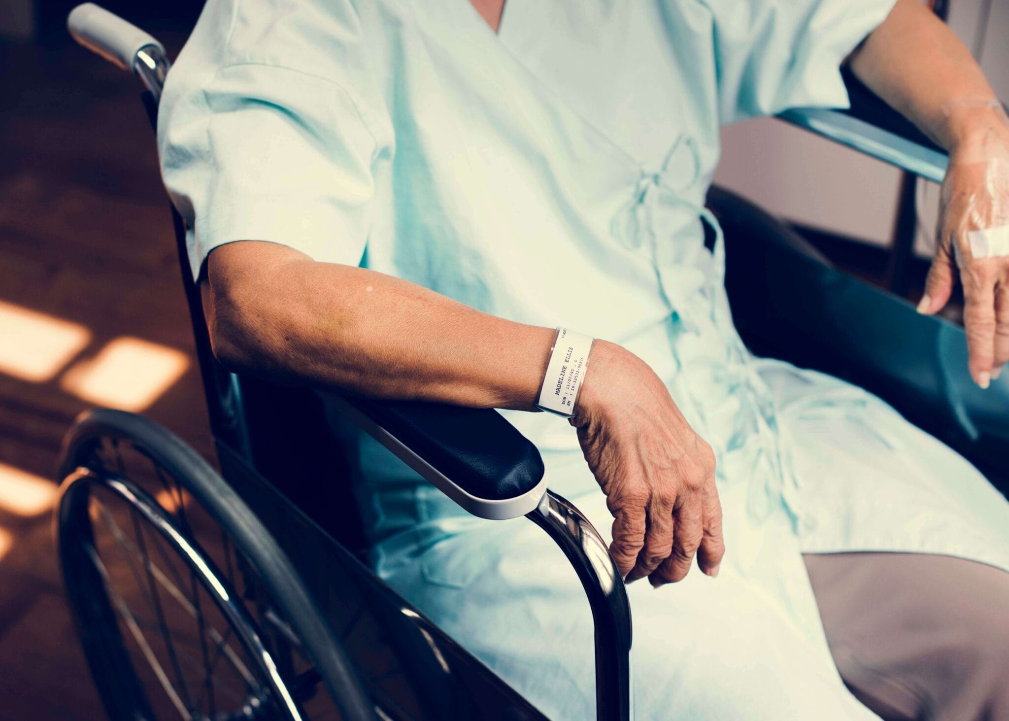 Old man sitting in wheelchair at the hospital in a hospital gown | RPA Advisors Retirement Medical Expenses