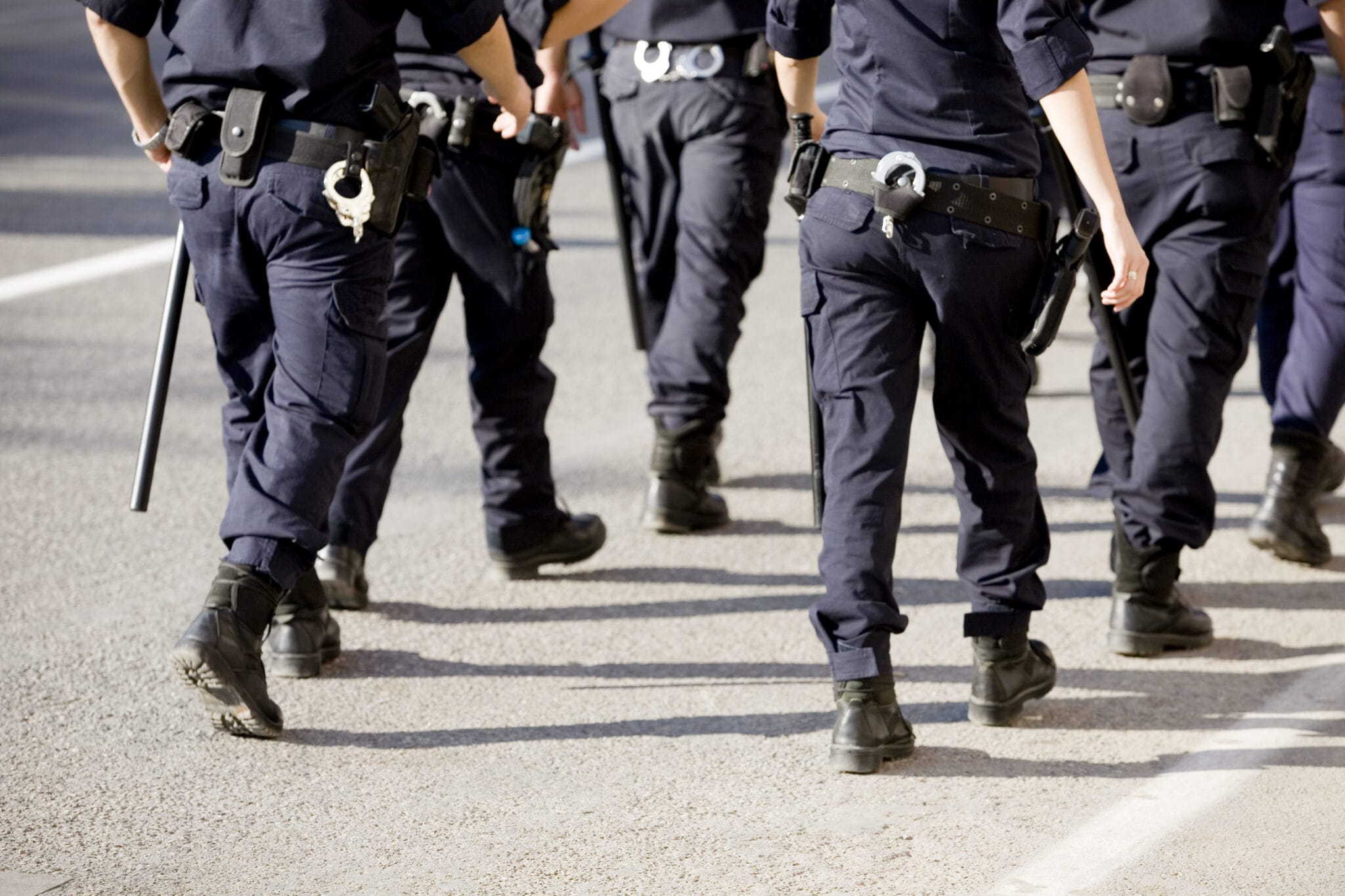 The legs of five police officers in uniform walking | Law enforcement union representation